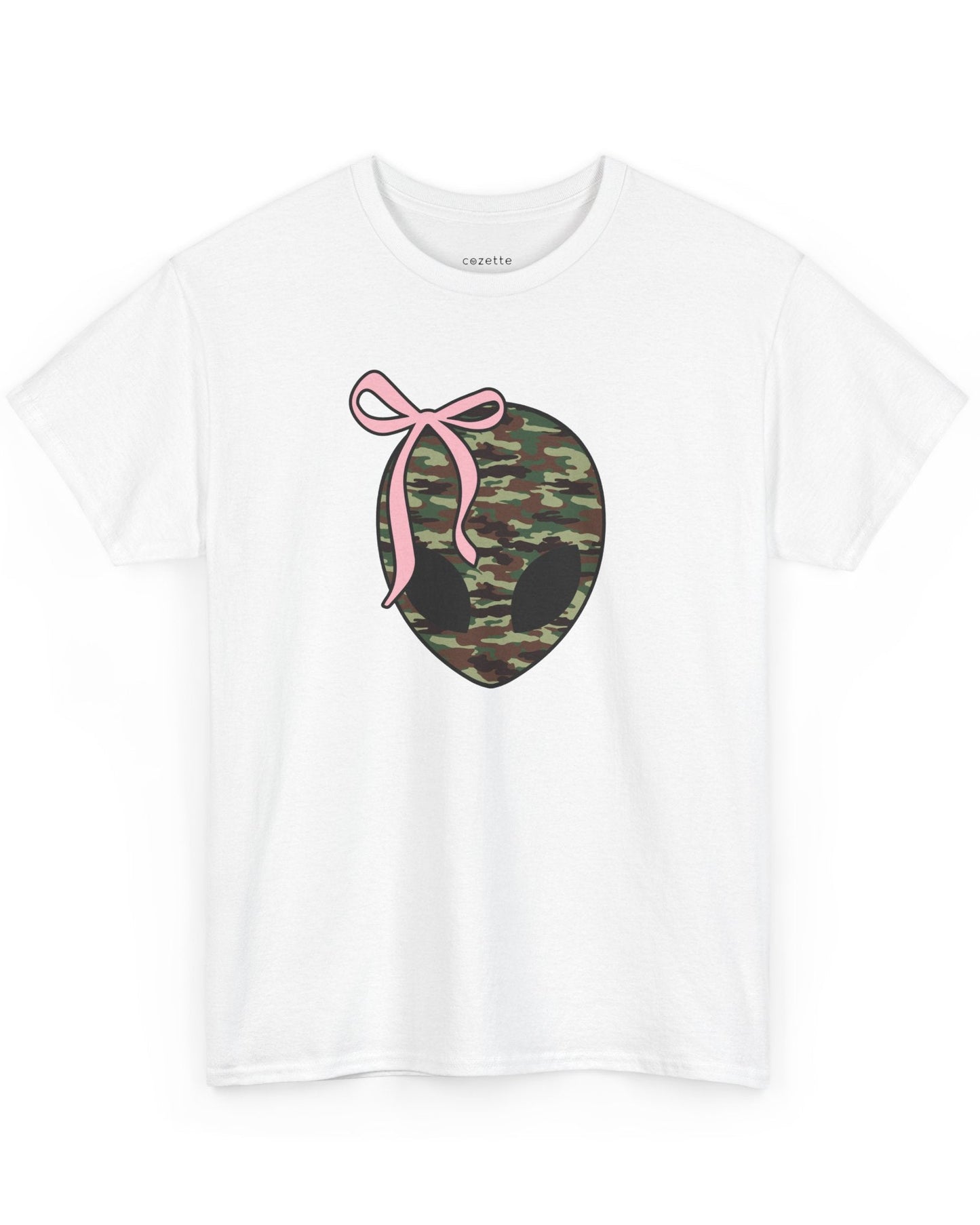 A child wearing a white t-shirt with a camo-patterned alien head and a pink bow on it.